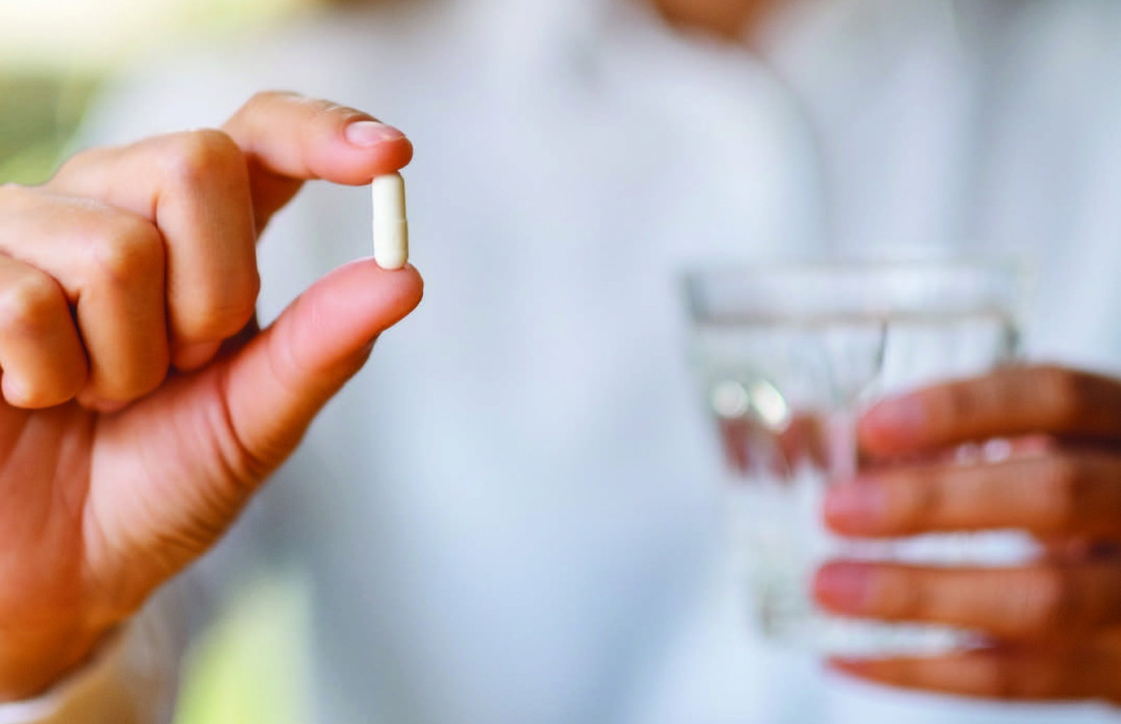 Detailný záber na ruku s tabletkou ako symbol dôležitosti každodenného dodržiavania liečby.